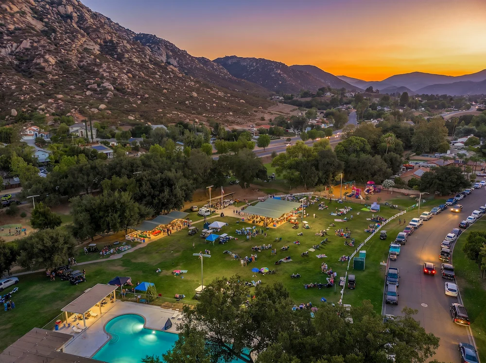 Aerial view of a sunset community concert on the green at San Diego Country Estates, with the granite mountains behind. Photo by Shellz Dezign Photography.